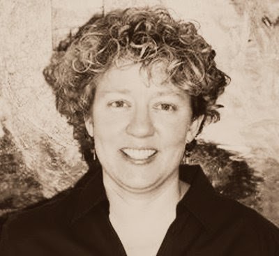 A sepia photo of a woman with curly hair and a big smile