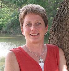 A woman with short blond hair wearing a red shirt 