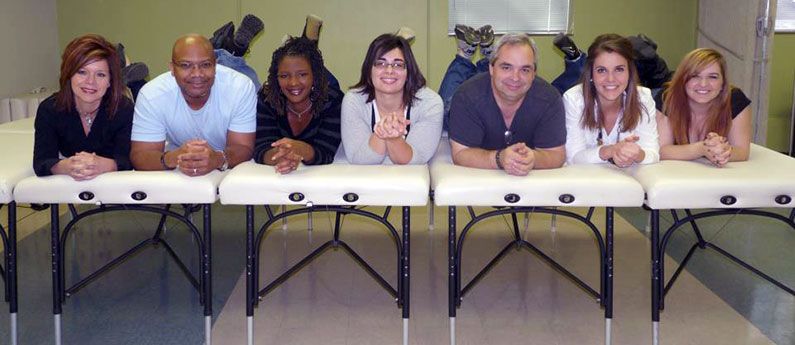 WellSpring students hamming it up for the camera, lining up and lying down on side-by-side massage beds.