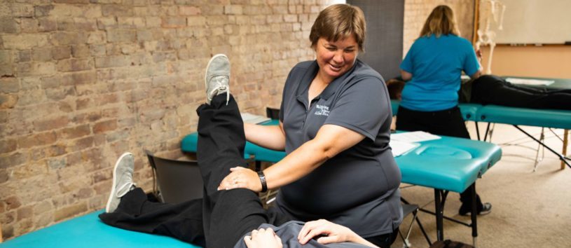 A massage student practices their technique on another student