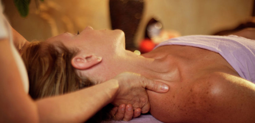 A woman gets a table massage from a massage therapist