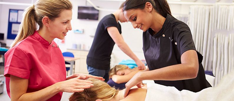 A student learning to treat a client during Wellspring's Massage Therapy Programs