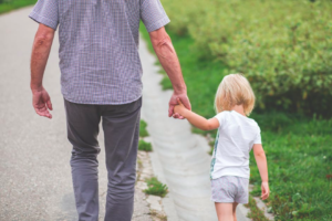 Parent and child, walking away hand-in-hand