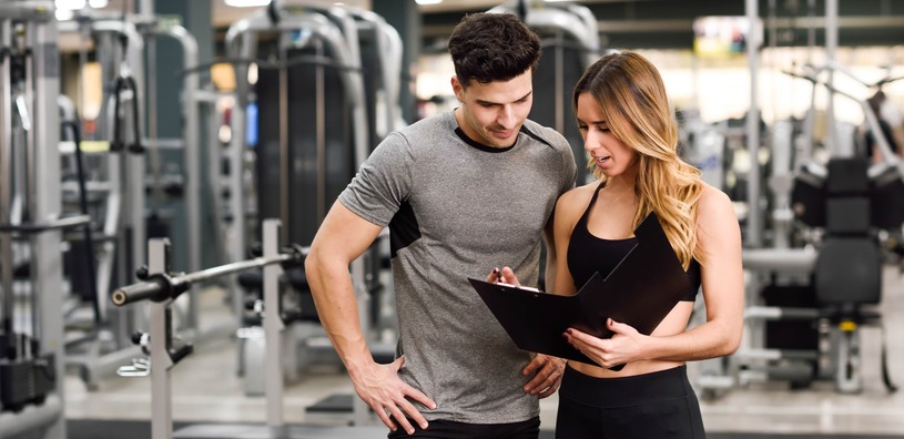 Fitness Trainers working together in a gym setting.